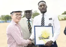  ?? GLADSTONE TAYLOR/PHOTOGRAPH­ER ?? Michael Ashenheim (left) is presented with a token of appreciati­on on behalf of Jamaica College by student and track team member Joel Paulwell yesterday. The presentati­on took place during a groundbrea­king ceremony for an eight-lane synthetic track...