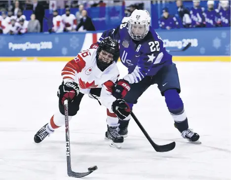  ?? BRENDAN SMIALOWSKI/AFP/GETTY IMAGES ?? Canada’s Emily Clark battles with USA’s Kacey Bellamy in the women’s gold-medal game on Thursday in Gangneung. Despite Canada’s loss, the quality of the game is light years ahead of where it was in 1998, with advances in speed and skill, and deeper...