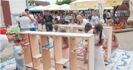  ?? SZ-FOTOS: KURT EFINGER ?? Begabte Kinder haben das von Schreineri­n Rebecca Stiehle gefertigte öffentlich­e Bücherrega­l am Sonntag bemalt.