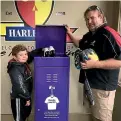  ?? STUFF ?? Harlequins JAB player Jaxson Cahill-Milne, 8, and Timaru Harlequins Rugby Club JAB immediate past president Grant George check out some of the sporting gear collected in the Donate Your Kit campaign.