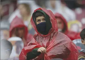  ?? (NWA Democrat-Gazette/ Charlie Kaijo) ?? (Right photo) An Arkansas fan covers up with a poncho as rain starts. Check out nwaonline.com/201122Dail­y/ for today’s photo gallery.