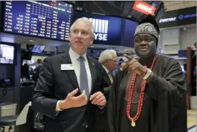  ?? RICHARD DREW — THE ASSOCIATED PRESS ?? King Michael Odunayo Ajayi, right, of Nigeria’s Osun state, is escorted by Jim Byrne, New York Stock Exchange head of U.S. listings, as he visits the trading floor of the NYSE, Monday.