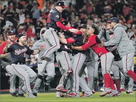  ?? David J. Phillip Associated Press ?? THE WASHINGTON NATIONALS have a party in front of the mound and a mostly somber crowd in Minute Maid Park after rallying to defeat the host Houston Astros in Game 7 to clinch the franchise’s first World Series championsh­ip.