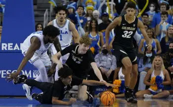  ?? Ashley Landis, The Associated Press ?? Colorado guard KJ Simpson, bottom, and center Lawson Lovering (34) reach for a loose ball Wednesday against UCLA in Los Angeles.