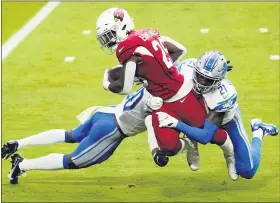  ?? RICK SCUTERI — THE ASSOCIATED PRESS ?? Arizona Cardinals running back Chase Edmonds is hit by Detroit Lions defensive back Tracy Walker and cornerback Jeff Okudah during the first half of Sunday’s game in Glendale, Ariz.