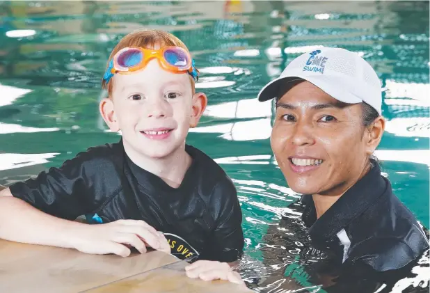  ?? Picture: BRENDAN RADKE ?? CONFIDENCE: Eamon Blackmore, 5, gets a swimming lesson from Kaname Woodfield at C-Me Swim swimming school, Edge Hill.