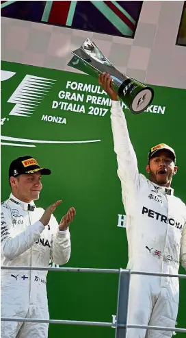  ??  ?? And the winner is: Mercedes’ British driver Lewis Hamilton (right) celebratin­g with second-placed Mercedes Finnish driver Valtteri Bottas on the podium after the Italian Grand Prix in Monza yesterday. — AFP