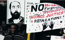  ?? Photo: David Forbes ?? Protesters at Vlok’s trial hold posters of Dr Wouter Basson and calls for reparation­s