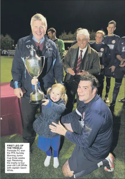  ??  ?? FIRST LEG OF THE TREBLE: Parkside FC won the PFA Sunday Morning Junior Cup three weeks ago. Receiving the trophy is four year-old Lolli White with captain Gavin White.