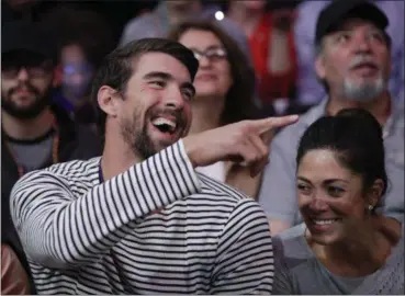  ?? ASSOCIATED PRESS FILE ?? Michael Phelps and his wife, Nicole Johnson, watch a game between the Lakers and the Clippers in March in Los Angeles.