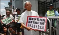  ?? (AP/Kin Cheung) ?? Hong Kong’s outspoken cardinal Joseph Zen (center) and other religious protesters hold placards with “Respects religious freedom” written on them during a demonstrat­ion on July 11, 2012, outside the China Liaison Office in Hong Kong.