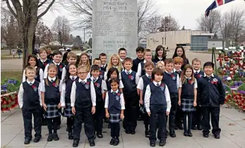  ??  ?? Left: Legion Branch 97 president Frank Murphy and member Patricia Lemaire hold up “Canada Proud,” which Patricia created and donated to the Branch. Right: St. Lawrence Academy students at the cenotaph.