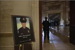  ?? BRENDAN SMIALOWSKI — POOL ?? A placard is displayed with an image of the late U.S. Capitol Police officer Brian Sicknick on it as people wait for an urn with his cremated remains to be carried into the U.S. Capitol to lie in honor in the Capitol Rotunda in Washington.