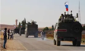  ?? Photograph: AFP via Getty Images ?? A convoy of Russian military vehicles drives towards the north-eastern Syrian town of Kobane.