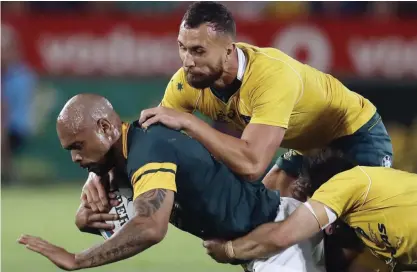  ?? — AP ?? PRETORIA: In this Oct. 1, 2016 file photo, South Africa’s Lionel Mapoe, left, is tackled by Australia’s Quade Cooper, top right, and teammate Bernard Foley, during the Rugby Championsh­ip match between South Africa and Australia, at Loftus Versfeld in...