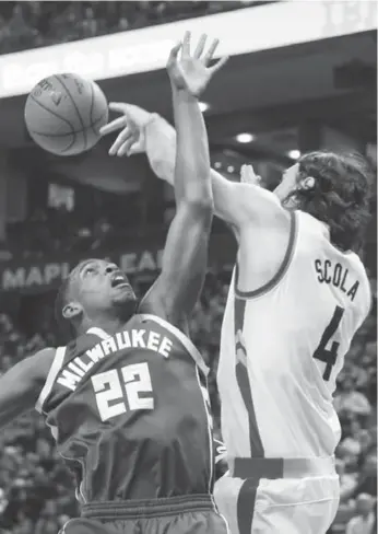  ?? BERNARD WEIL/TORONTO STAR ?? Milwaukee’s Khris Middleton loses the ball to Raptors forward Luis Scola. Middleton finished with 26 points.