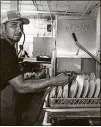  ??  ?? Dishwasher Hector Noel Cruz stands next to the old Auto-Chlor machine at Matthews Cafeteria.