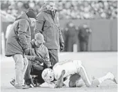  ?? CHARLES TRAINOR JR./MIAMI HERALD ?? Dolphins trainers attend to receiver Jakeem Grant after he was injured in the fourth quarter against the Packers.