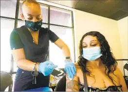  ?? ROGELIO V. SOLIS AP ?? Tameiki Lee (left) administer­s a Moderna COVID-19 vaccine for Betty White at Jackson-Hinds Comprehens­ive Health Center in Jackson, Miss., on July 19.