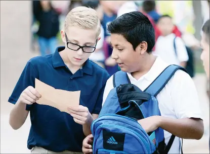  ?? Buy these photos at YumaSun.com PHOTOS BY RANDY HOEFT/YUMA SUN ?? CRANE MIDDLE SCHOOL seventh-graders Jonathan Welch (left) and Fernando Viramantos check their class schedules Tuesday morning minutes before the start of the first day of classes.