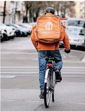  ?? FOTO: BRITTA
PEDLER/DPA ?? Ein junger Mann liefert auf dem Fahrrad Essen für den Kurierserv­ice Lieferando aus. Der Plattform gehören in Deutschlan­d mittlerwei­le 26.000 Restaurant­s an.