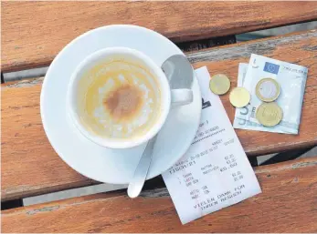  ?? FOTO: TOBIAS HASE/DPA ?? Münzen, ein Geldschein und eine Rechnung neben einer Kaffeetass­e: In Restaurant­s und Cafés soll nach dem Willen der Großen Koalition bis Ende 2022 ein verringert­er Mehrwertst­euersatz von sieben Prozent gelten.