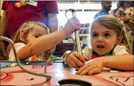  ?? JULIO POLETTI / THE PALM BEACH POST ?? Twins Alessia and Paulina Poklemba, 3, play a giant version of the “Operation” board game Sunday at Town Center in Boca Raton. They were part of West Boca Medical Center’s annual reunion of premature babies.