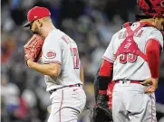  ?? DAVID ZALUBOWSKI / AP ?? Cincinnati Reds relief pitcher Art Warren (left) walks away from catcher Aramis Garcia as he heads for the dugout. Warren gave up a triple to Ryan McMahon of the Rockies to allow in two runs in the sixth inning of the Reds 4-3 loss Saturday night in Denver.