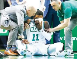  ??  ?? Team personnel assist Boston Celtics' Kyrie Irving (11) after he was injured during the first quarter of an NBA basketball game against the Charlotte Hornets in Boston. Irving took an elbow to the face and left the game. (AP)