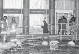  ?? Dmitri Lovetsky / Assoicated Press ?? Police guard the entrance of a supermarke­t after an explosion Wednesday in St. Petersburg, Russia, injured at least 10 people.