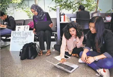  ?? Michael Macor / The Chronicle ?? Zahra Billoo (left), Sacha Maniar and Joyce Xi set up a legal advice station to provide free help for arriving passengers at San Francisco Internatio­nal Airport as the Trump administra­tion’s travel ban starts up again following the Supreme Court ruling.