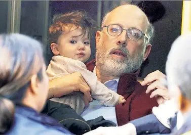  ??  ?? QUICK ACTION: A father holds his baby Thursday after grabbing her from the 72nd Street subway tracks.