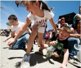  ?? TAOS NEWS FILE PHOTO ?? Kids scramble for candy tossed by Arroyo Seco July 4th Parade participan­ts at a past event. It’s a small village with a big parade that causes huge smiles.