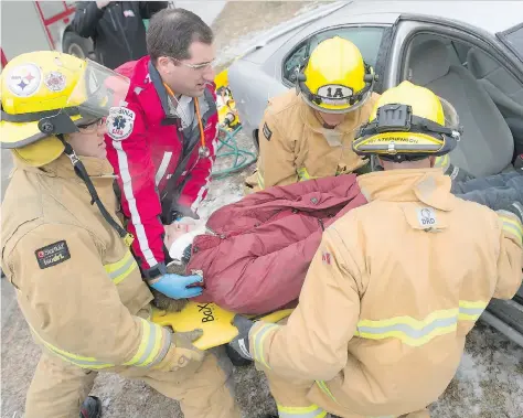  ?? MICHAEL BELL ?? Regina Fire and Protection Services and EMS crews remove Martin Collegiate student Sebastian Eger from a car during a mock accident. The event was staged to draw attention to the need for blood donations as part of a competitio­n the first responders...