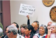  ??  ?? A protester holds up a sign in opposition to a proposed ordinance that would regulate oil and gas developmen­t in Sandoval County before the start of Thursday night’s meeting.