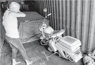  ?? Elizabeth Conley / Houston Chronicle ?? Sherry Goodwine checks out a vintage scooter that had flooded in its storage unit in Moss Bluff.