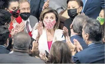  ?? J. SCOTT APPLEWHITE/AP ?? Speaker Nancy Pelosi, center, celebrates with Democratic lawmakers on Friday after the House voted.