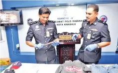  ??  ?? Chandra (left) inspecting the machete that was used in the robbery.