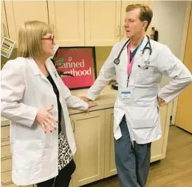  ?? SARAH VARNEY/KAISER HEALTH NEWS ?? Dr. Janet Cathey, left, and nurse practition­er Gordon Low work at Little Rock Planned Parenthood in Arkansas. The state has largely outlawed abortion, but the organizati­on still offers contracept­ion and pregnancy tests.