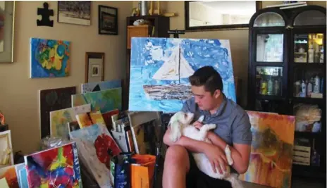  ?? ALEX MCKEEN PHOTOS/TORONTO STAR ?? Artist Aidan Lee, 13, holds his therapy dog, Chebe, in his home in Oakville. He is well on his way toward a goal of teaching art to 150 children by July 1.