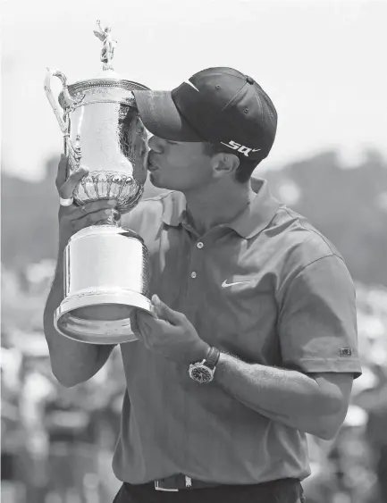  ?? AP ?? In this June 18, 2008 file photo, Tiger Woods kisses his U.S. Open championsh­ip trophy after winning a sudden-death playoff against Rocco Mediate following an 18-hole playoff round for the title, at Torrey Pines in San Diego. This is the 10-year...