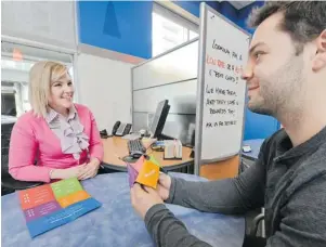  ?? GLENN BAGLO/ PNG FILES ?? Taylor Warnick, left, and customer Alex Wingert discuss fi nance options at a Coast Capital branch in Vancouver. Many millennial­s are more savvy with money than their parents, a survey fi nds.