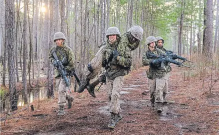  ??  ?? Marine recruits move through a simulated combat situation during the Crucible, a grueling 54-hour field exercise, at Parris Island, S.C., on Feb. 21. Keeping men and women in separate platoons during recruit training is the last stand for the Marine Corps, which has been slow to move toward gender integratio­n.