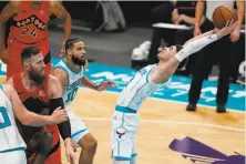  ?? Chris Carlson / Associated Press ?? Hornets guard LaMelo Ball grabs one of his 10 rebounds in his first time on an NBA court, an exhibition against Toronto.