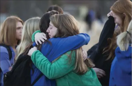  ?? RYAN HERMENS — THE PADUCAH SUN VIA AP ?? Students embrace following a prayer vigil at Paducah Tilghman High School in Paducah, Ky., Wednesday in Paducah, Ky. The gathering was held Tuesday for the victims of the Marshall County High School shooting.