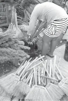  ?? JOY TORREJOS ?? Many residents of Barangay Paknaan in Mandaue City depend on the business of making brooms for their livelihood. The barangay holds a yearly festival celebratin­g this local industry.