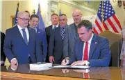  ?? SARAH PHIPPS/THE OKLAHOMAN VIA AP ?? On Dec. 13, Oklahoma Gov. Kevin Stitt signs an executive order in the Blue Room of the state Capitol in Oklahoma City.