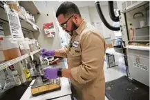  ??  ?? Chemical technician Victor Guajardo makes a blend in the labs at Huntsman Corp. in The Woodlands.