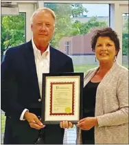  ?? Photo by Hope Duke ?? Heather Finley, president of the Gravette School Board, presents Richard Page, superinten­dent of Gravette Public Schools, with a proclamati­on from Gravette mayor Kurt Maddox proclaimin­g Monday, May 11, as Dr. Richard Page Day in Gravette. Page, who is retiring at the end of the year, was honored at the Monday school board meeting.