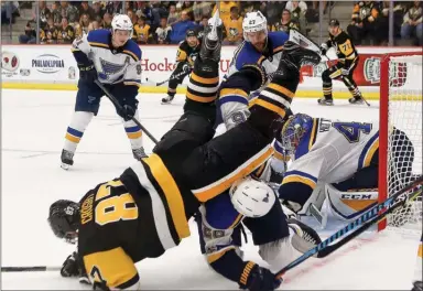  ?? The Associated Press ?? Pittsburgh Penguins’ Sidney Crosby (87) is upended by St. Louis Blues’ Paul Stastny as he tries to get to the puck in the goal crease during the third period of the NHL preseason hockey game, Sunday. The Blues won 4-1.